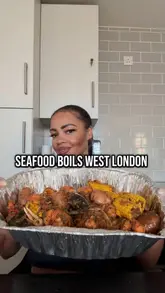 Diners enjoying a seafood boil at Sweetz Seafood Kitchen in London, featuring vibrant dishes and a lively atmosphere.