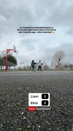 Couple enjoying a playful moment practicing basketball free throws together, celebrating fitness and fun.