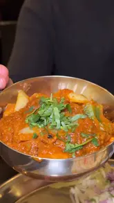 A close-up, handheld montage of various Indian street food dishes including pav bhaji, pani puri, samosa chaat, chilli paneer, chicken karahi, paneer makhni, and kadak chai.