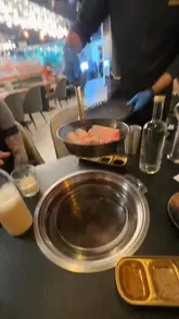 A review of a Chinese charcoal BBQ restaurant, featuring various meats and sides being cooked at the table. The creator provides commentary on the food and the experience.