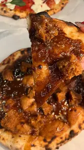 A short, punchy review of Panzer's Deli and its in-house pizzeria, Circus Pizza. The video showcases the unique 'Sticky Toffee Pudding Pizza', along with other menu items like arancini and fresh juices, while giving a quick tour of the deli and outdoor seating area.