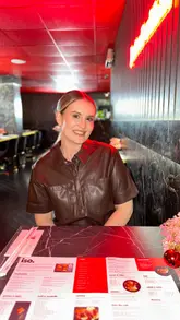 A couple visits a casual sushi restaurant, showcasing a variety of dishes including sushi rolls, bao buns, gyoza, a burger, and Japanese desserts. The video features the creators trying the food in a relaxed, modern setting.