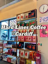 A static, eye-level shot of a retail shelf at Hard Lines Coffee in Cardiff, displaying various bags of coffee beans. The image is functional but lacks artistic composition or styling, serving primarily as a straightforward documentation of the shop's retail display.