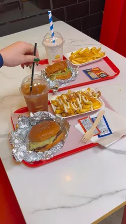 Enjoying a delicious smash patty burger at Muncheez, the ultimate American comfort food spot in London.