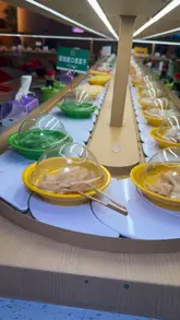 A vlog-style review of a Korean and Japanese hotpot and sushi restaurant. The creator walks through the ordering process via QR code, shows the conveyor belt system, and samples various dishes including sushi, fried chicken, wagyu beef, and lobster, highlighting the interactive and fun nature of the dining experience.
