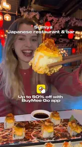 A short, energetic video review of Sumiya, a Japanese restaurant in London. The creator showcases various sushi dishes, a cocktail, and the restaurant's interior, which features cherry blossom decor and karaoke facilities. The video also highlights a discount offer available via the BuyMee GO app.