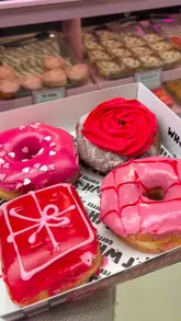 A short promotional video showcasing a limited edition Valentine's Day donut box from Whocult. The video features close-up shots of the donut display case, the shop's interior, and the final product box.
