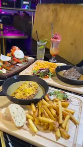 A promotional montage for MYNK Steakhouse in Bradford, featuring close-up shots of various dishes including a chef's platter, steaks, and dessert, interspersed with glimpses of the restaurant's modern, neon-lit interior.