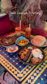 A montage showcasing the interior and food menu of Oasis Lounge, a Moroccan restaurant. The video features close-ups of various dishes like lamb tagine, mixed grill, and desserts, interspersed with shots of the restaurant's ornate, lantern-lit decor.