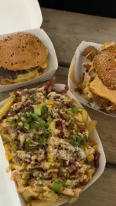 A short, energetic montage showcasing a visit to a burger pop-up located at a brewery taproom. The video captures the journey from arrival to ordering, featuring close-ups of loaded fries and burgers, as well as the casual atmosphere of the venue with sports on the screens.