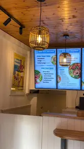 A short, energetic reel showcasing a poke bowl restaurant, featuring shots of the menu board, the prepared bowls, and close-ups of sides like gyoza and mochi.