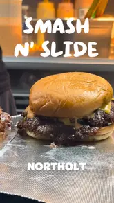 A short montage showing the preparation of smash burgers, including grilling, smashing, and assembling, followed by a shot of the finished product.