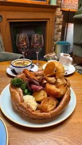 A review video of a Sunday roast at The Spotted Horse in Putney, featuring a giant Yorkshire pudding filled with various meats and sides, followed by desserts.