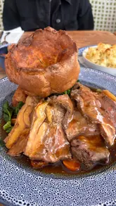A montage video showcasing a visit to Coppa Club at The Swan at Streatley, featuring the interior, the waterside setting, and a selection of Sunday roast dishes and desserts.