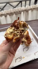 A short, montage-style video showcasing a tiramisu-flavored pastry at Fred Bakery, focusing on the texture and appearance of the bun.