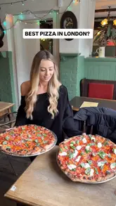 A food influencer visits a new pizza residency at a pub in Brentford, showcasing the preparation process, the venue's waterside location, and tasting the 18-inch pizzas.