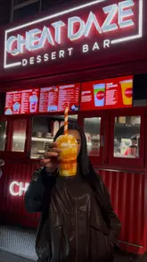 A short, fast-paced promotional video for Cheat Daze, a late-night dessert drive-through in Manchester. The video highlights the convenience of the QR code ordering system and showcases the indulgent, topping-heavy desserts and drinks available.