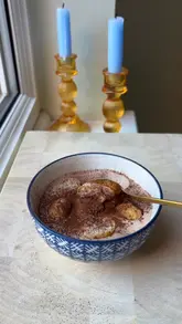 A short, instructional video demonstrating how to make a high-protein tiramisu-style dessert using Greek yogurt, protein powder, coffee, and ladyfingers.