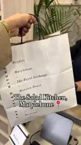 A short video showing the assembly of a custom salad bowl at The Salad Kitchen, followed by the creator taking it to a park to eat.