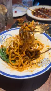 A montage of various Sichuan dishes at a Michelin-listed restaurant in Soho, featuring close-ups of salt and pepper chicken, gong bao chicken, stir-fried lamb, dumplings, Dan Dan noodles, and a glutinous rice cake dessert.