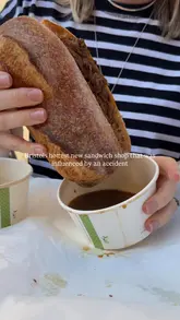 A short, punchy review of a sandwich stall in St Nicks Market, Bristol, focusing on their French dip sandwiches. The video features close-ups of the food being dipped in jus, the creators enjoying the meal, and shots of the market environment.