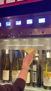 A short promotional video showcasing a new self-service wine dispenser at a wine bar in Jesmond. The video features shots of the dispenser in action, a glass of wine being poured, a charcuterie board, and the venue's upstairs seating area with customers.