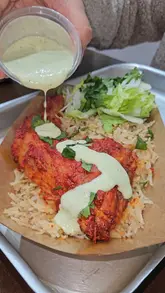 The video provides a tour of the menu at Aroma Cafe, highlighting their paratha rolls, various indulgent cookies, and a pistachio tiramisu latte. It uses a mix of close-up food shots and menu displays to entice viewers.