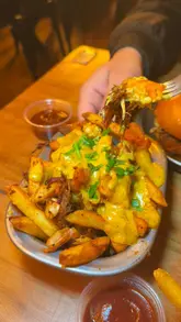 A short montage video showcasing various burgers, loaded fries, and chicken wings at Salt's Smokehouse, interspersed with a brief shot of the venue's interior.