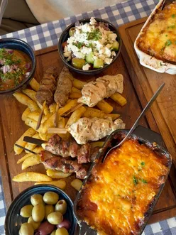 Loaded Greek sharing platters with spanakopita, dips, and sides on a table at Yiayia's Kitchen in Winchester.