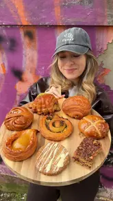 A couple visits Oast Bakery in Margate, Kent, to review their selection of artisan pastries and breads. The video features a tour of the bakery, a glimpse of the baking process, and a taste test of various items including danishes, buns, and sourdough loaves.