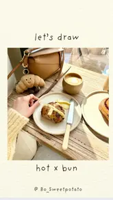 The video features a creator in a London bakery, enjoying a hot cross bun and a flat white while sketching the scene. It captures a relaxed, aesthetic atmosphere typical of a weekend brunch or coffee break.