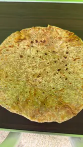 A creator visits Sizzle and Serve, a market stall in Rochdale, to review their homemade Desi breakfast offerings, specifically highlighting the parathas and chicken pakora.