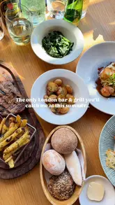 A fast-paced, music-synced montage showcasing a variety of dishes including scallops, prawns, salmon, steak, and churros, alongside shots of the venue's interior, a live saxophonist, and a DJ.