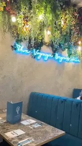 A couple visits Chai Green in Manchester, showcasing a variety of dishes including wings, kebab rolls, curry, rice, and desserts, alongside drinks and the venue's interior.