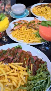 A montage of various dishes served at Brothers Exeter, including steak, chicken, shrimp, and small plates, followed by a shot of the menu.
