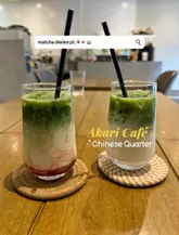 A clean, well-composed, and inviting photograph of two matcha lattes served on a wooden table, effectively showcasing the product for a cafe setting.
