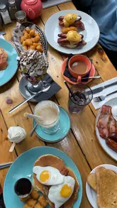 A review of 'Hole in the Wall' in Crosby, showcasing their breakfast and brunch menu, including milkshakes, pancakes, and eggs benedict. The video highlights the venue's family-friendly features, such as a dedicated kids' play area, and mentions their current deals.