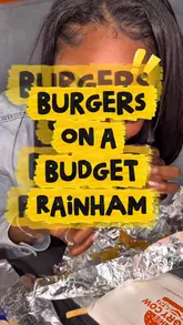 A pair of creators visit The Hungry Cow in Rainham to review their affordable burger and fast food menu. The video features close-ups of various items including loaded fries, burgers, and sides, with the creators providing commentary on the taste and value.