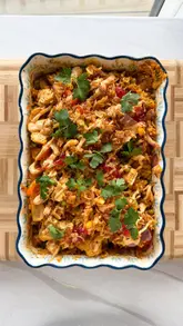 A high-energy, fast-paced recipe tutorial demonstrating how to make a budget-friendly Peri Peri Tofu Rice Bake. The creator walks through the ingredients and preparation steps, resulting in a visually appealing final dish.
