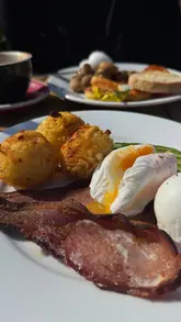 A short, handheld vlog showcasing a brunch visit to George St Canteen in St Albans, highlighting the outdoor seating area and a classic brunch plate of hash browns, poached eggs, bacon, and avocado.