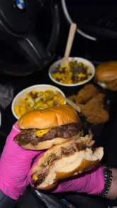 A short, fast-paced video featuring a person in a car at night showcasing a variety of takeaway food items including burgers, loaded fries, wraps, and milkshakes. The video uses quick cuts and close-up shots to highlight the food, set to music.