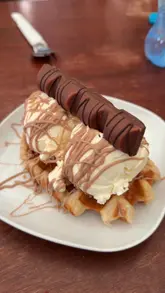 A casual venue tour of Basil & Rusty's Ice Cream Parlour, highlighting the family-friendly outdoor play area, wood-fired pizza, and sweet treats like waffles and ice cream.