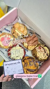 A short, handheld vlog-style reel documenting a visit to Chulo's cookie shop as part of the Glasgow Bake Trail. The video features shots of the shop's exterior and interior, the cookie display case, and a close-up of a box of assorted stuffed cookies.