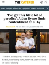 A professional portrait of chef Aiden Byrne and his partner Sarah Byrne, taken for a feature in The Caterer magazine about their restaurant, Li-Ly. The image conveys a warm, welcoming atmosphere suitable for a fine dining establishment.