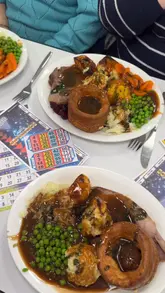 The video is a vlog-style review of a visit to Castle Bingo, focusing on the Sunday roast meal and the bingo experience. The creators show the venue, the food service, the bingo cards, and their reactions to the meal and the game.