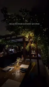 A polished montage showcasing the interior and food offerings of a restaurant, featuring dishes like scallops, beef wellington, and bread, set in a cozy, atmospheric environment with fairy lights.