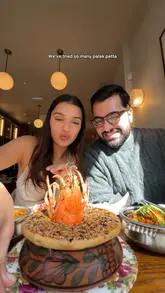 A couple visits Empire Empire in Notting Hill, a boutique Indian restaurant, to review their menu. They showcase a wide array of dishes including lobster biryani, various kebabs, and desserts, highlighting the quality and attention to detail in the food.