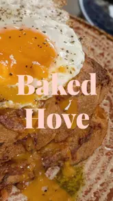 A short, energetic reel showcasing a brunch visit to Baked in Hove. The video features close-ups of coffee, avocado toast, a savory French toast dish with a fried egg, and brunch cocktails like a Bloody Mary and Mimosa. It captures the busy, dog-friendly atmosphere of the cafe.