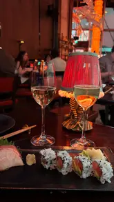A montage showcasing the interior, drinks, and various dishes at Sexy Fish Manchester. The video highlights the restaurant's dark, aquarium-themed decor, live music, and a variety of Japanese-inspired plates including sushi, sashimi, and cooked mains.