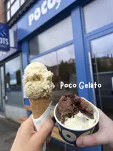 A casual, first-person perspective shot of two ice cream servings (a cone and a cup) held in front of the Poco Gelato shopfront in Netherlee.